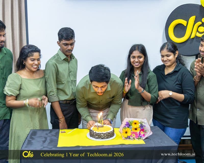 A Techloom.ai teammate lighting the first anniversary cake while the team claps